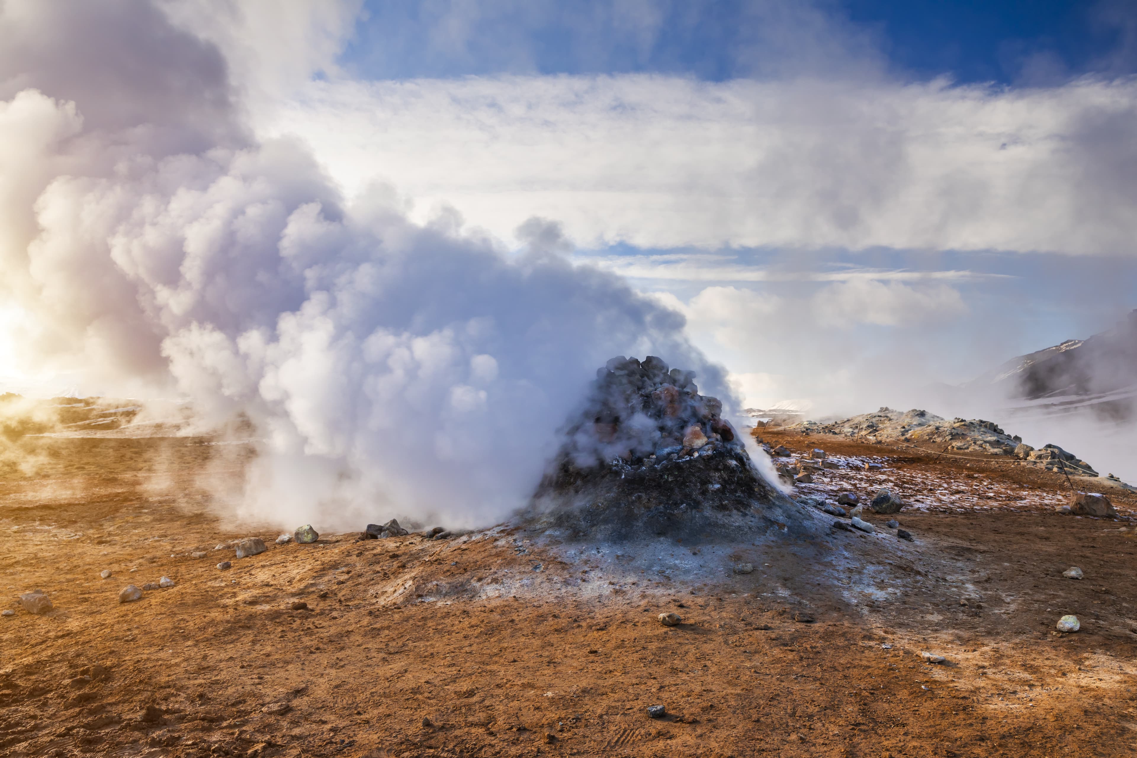 Namafjall Hverir geothermal area in Iceland. Stunning landscape of sulfur valley with smoking fumaroles and blue cloudy sky, travel background, tourist attraction Namafjall Hverir geothermal area in Iceland. Aerial view