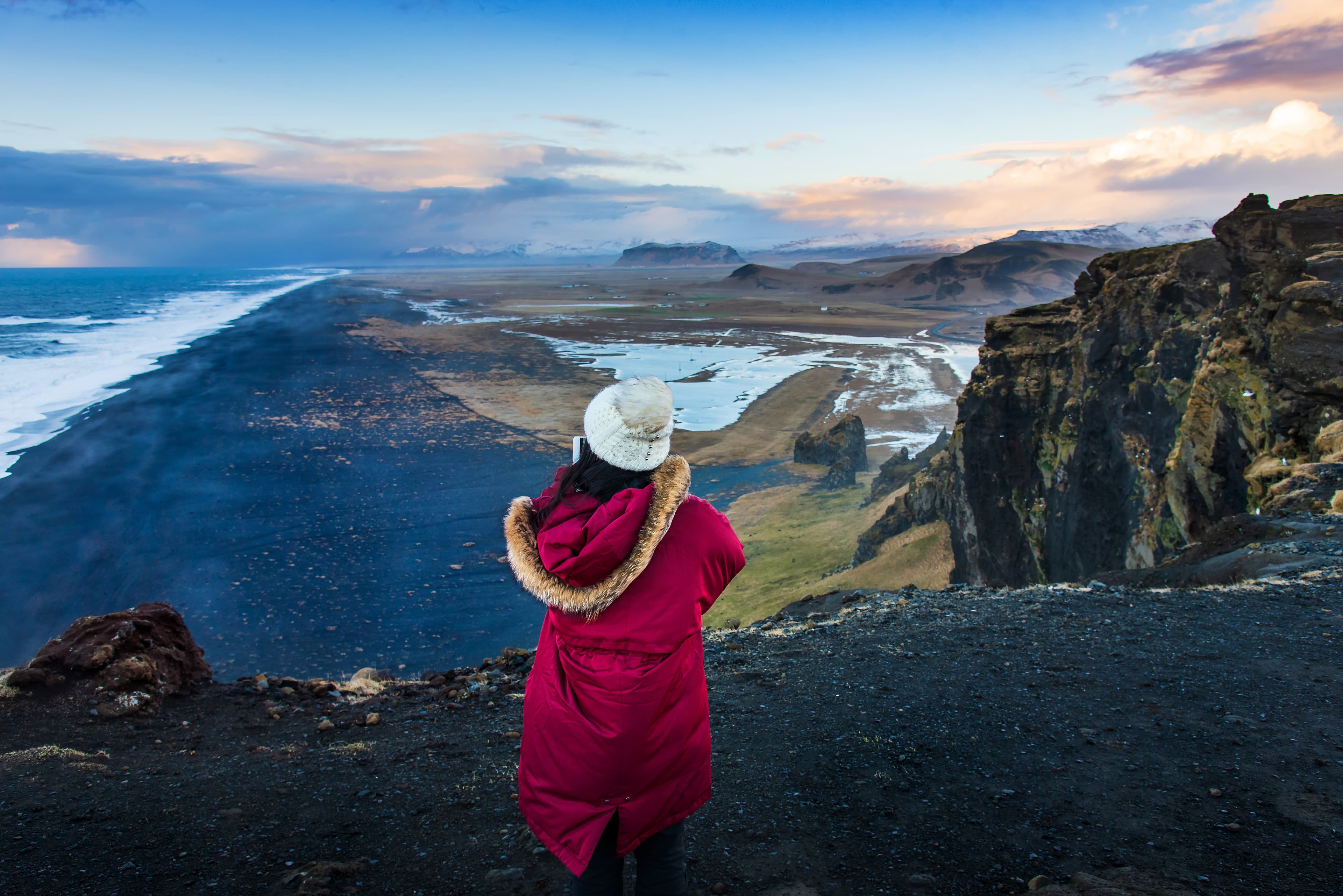 Traveler fotographing the Black sand beach view in Iceland from a scenic spot Traveler fotographing the Black sand beach view in Iceland