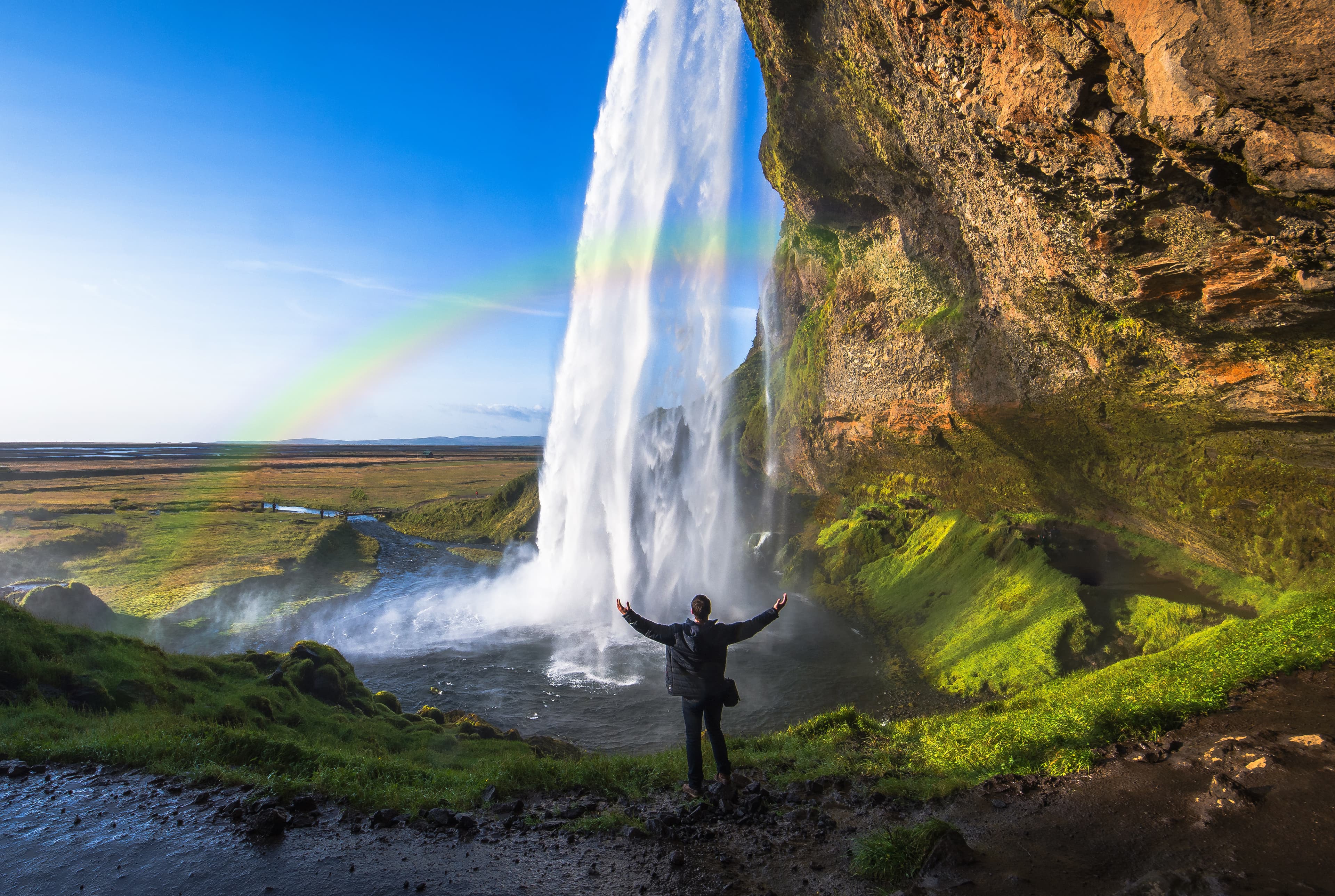 Tourist standing in front of Seljalandsfoss one of the best known waterfalls in southern Iceland, The most famoust Icelandic waterfall , beautiful amazing landscape from Iceland, Tourist standing in front of Seljalandsfoss one of the best known waterfalls in southern Iceland, Seljalandsfoss , Iceland
