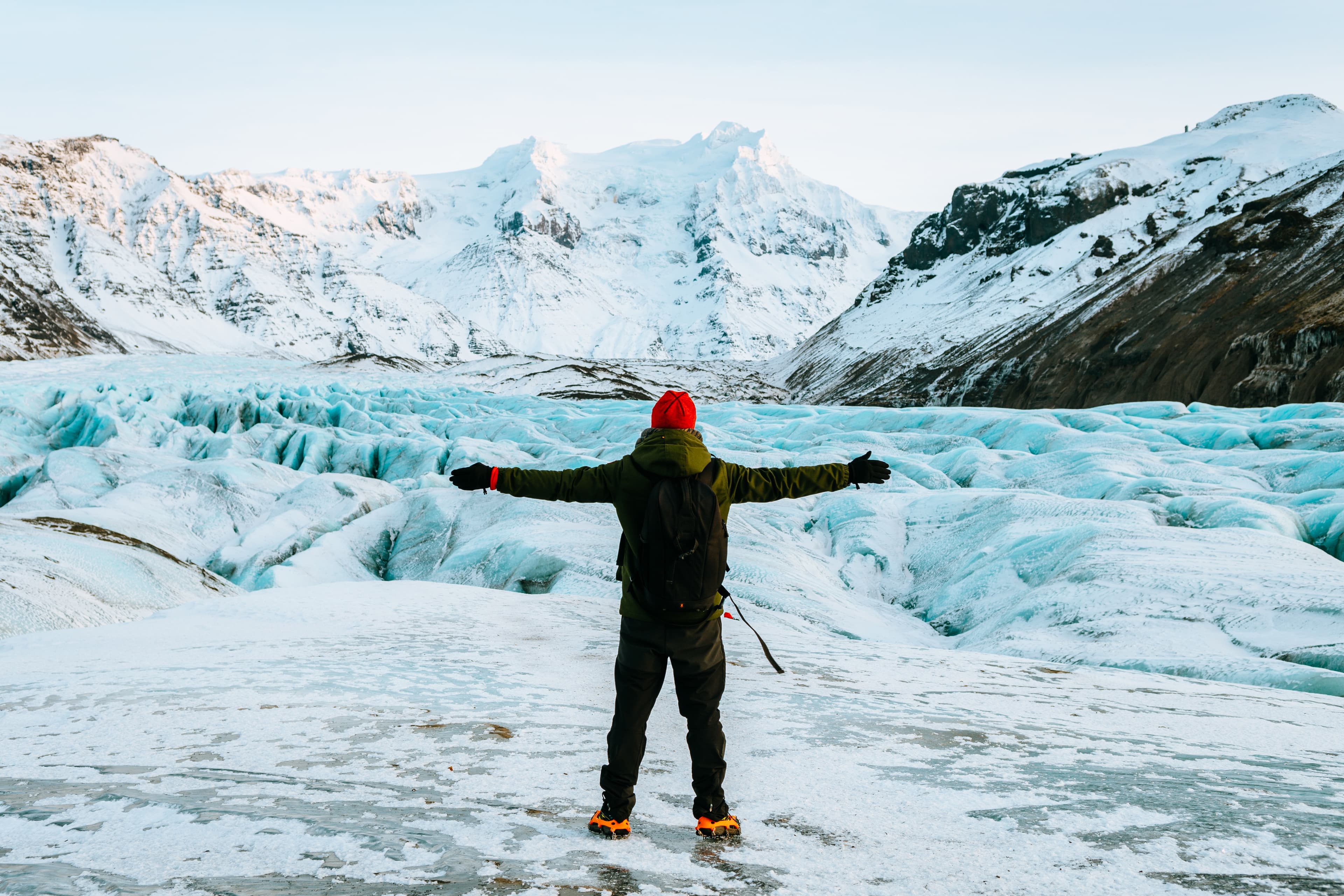 man-spreads-arms-during-hiking-on-glacier-in-iceland
