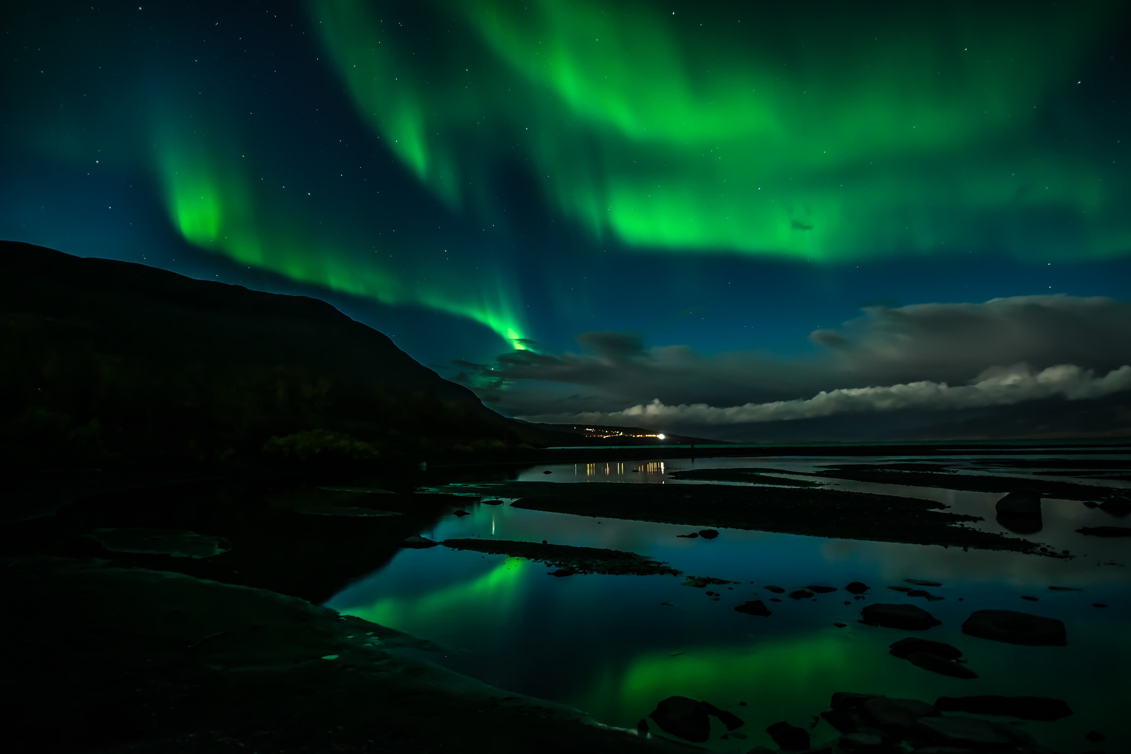 Northern lights dancing over calm lake in Abisko national park