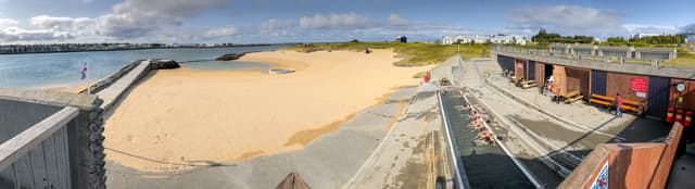 REYKJAVIK, ICELAND - AUGUST 11, 2019: Nautholsvik Geothermal Beach on a sunny summer day. It is a sandy beach with a man made hot spring. REYKJAVIK, ICELAND - AUGUST 11, 2019: Nautholsvik Geothermal Beach on a sunny summer day. It is a sandy beach with a man made hot spring