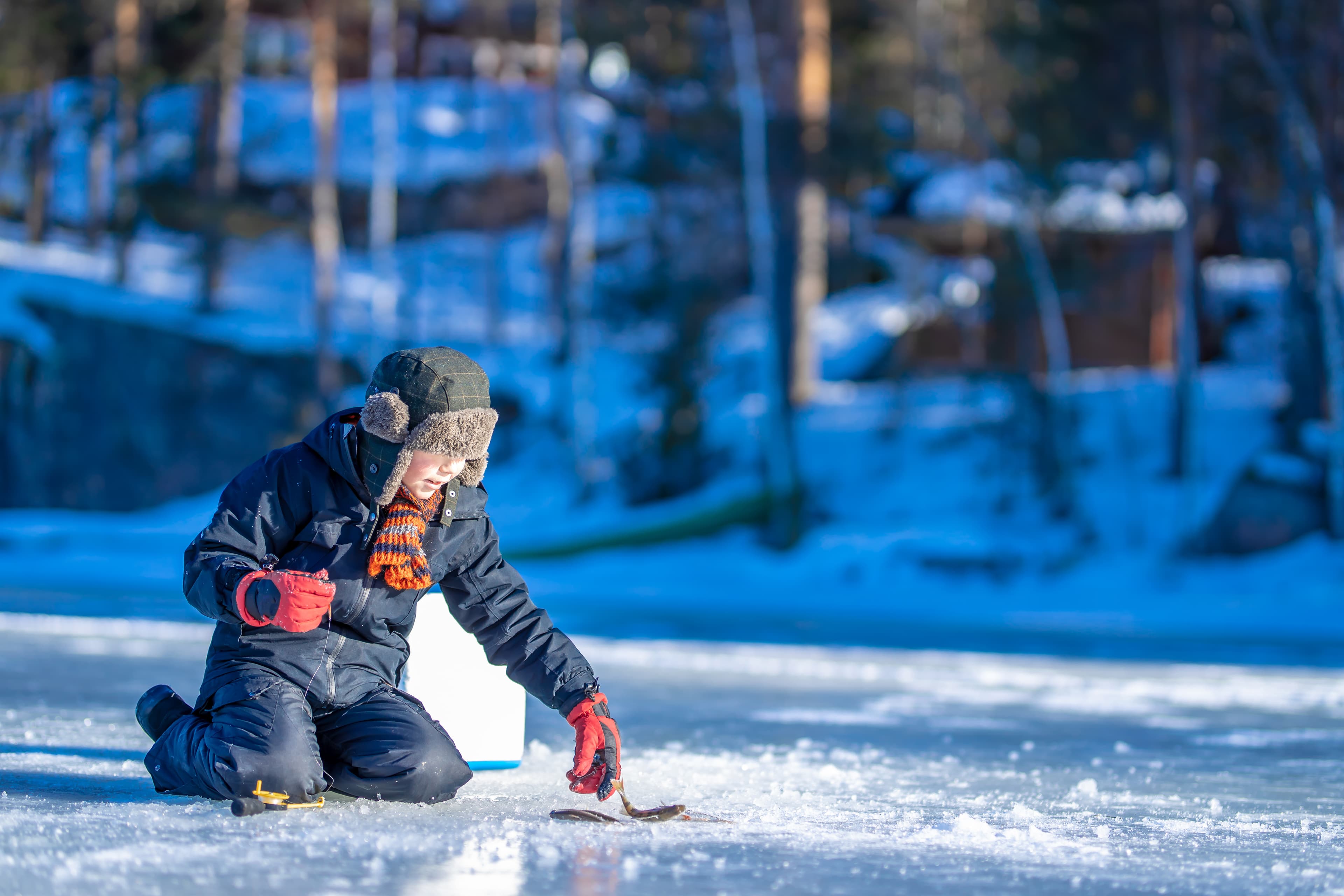 Boy at the winter fishing on frozen lake Boy at the winter fishing on frozen lake