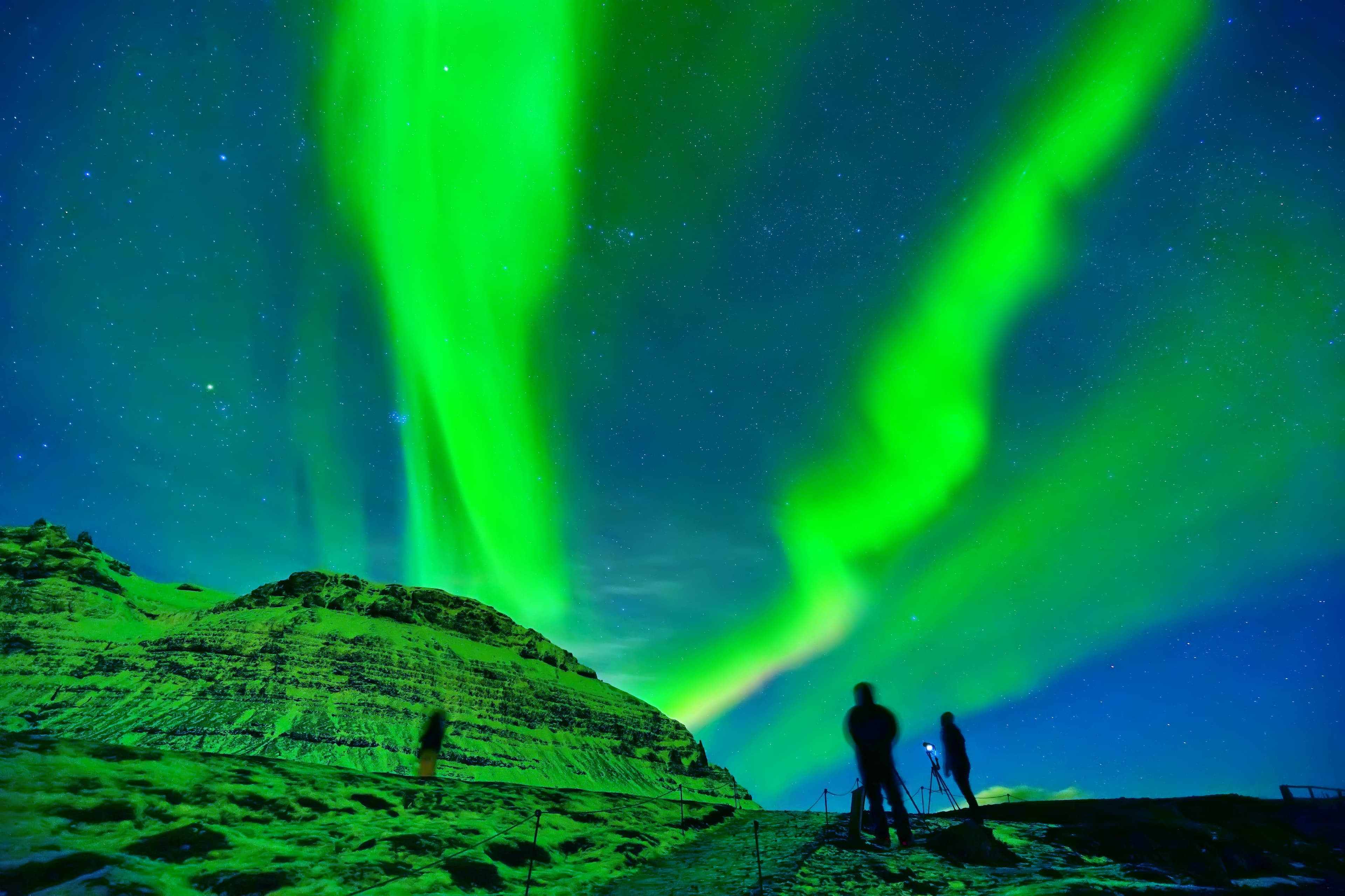 View of the northern light with photographers expecting near Kirkjufell Mountain in Iceland.