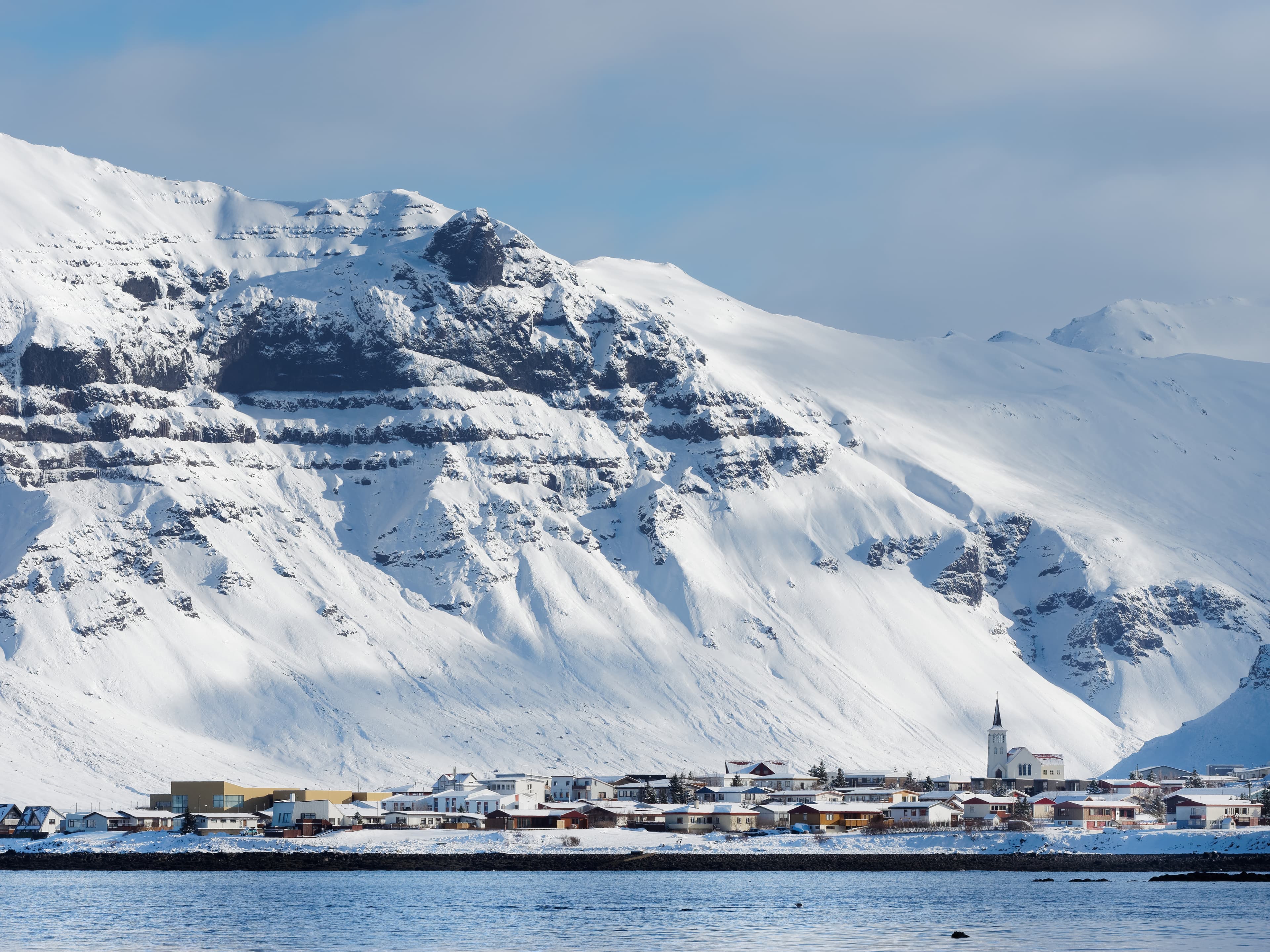 Grundarfjordur small coastal town in Snæfellsnes peninsula north side, Iceland, with snow covered mountains in the background. Grundarfjordur village, Iceland in winter