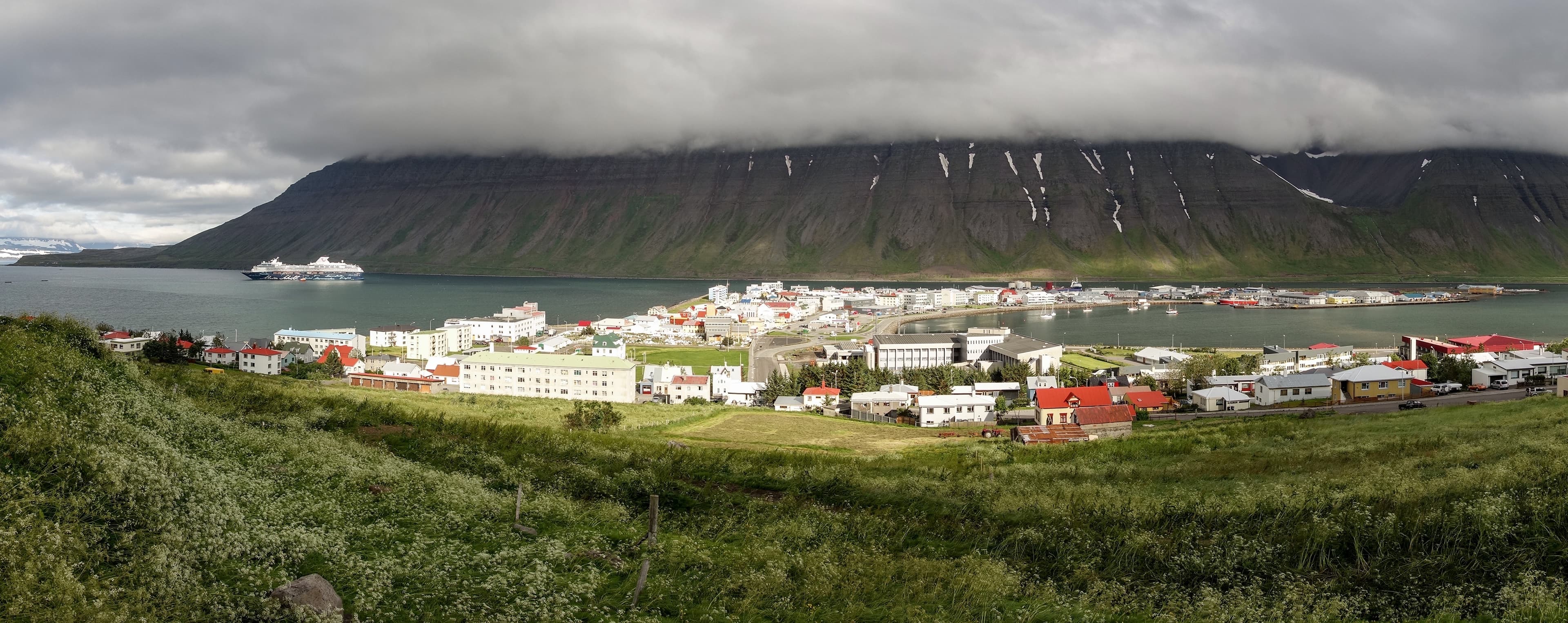 Wide-angle panorama of the Isafjordur city in Iceland with storm and fog coming Wide-angle panorama of the Isafjordur city in Iceland with storm and fog