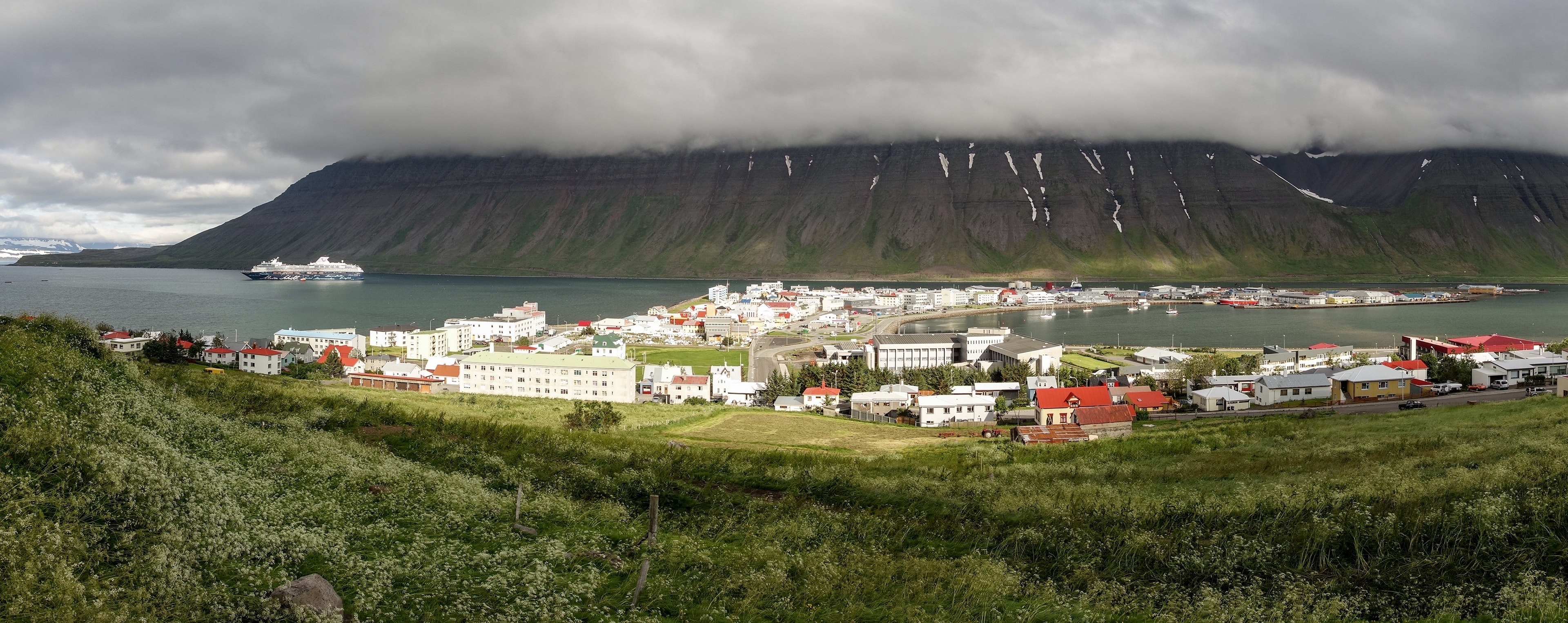 Wide-angle panorama of the Isafjordur city in Iceland with storm and fog coming Wide-angle panorama of the Isafjordur city in Iceland with storm and fog
