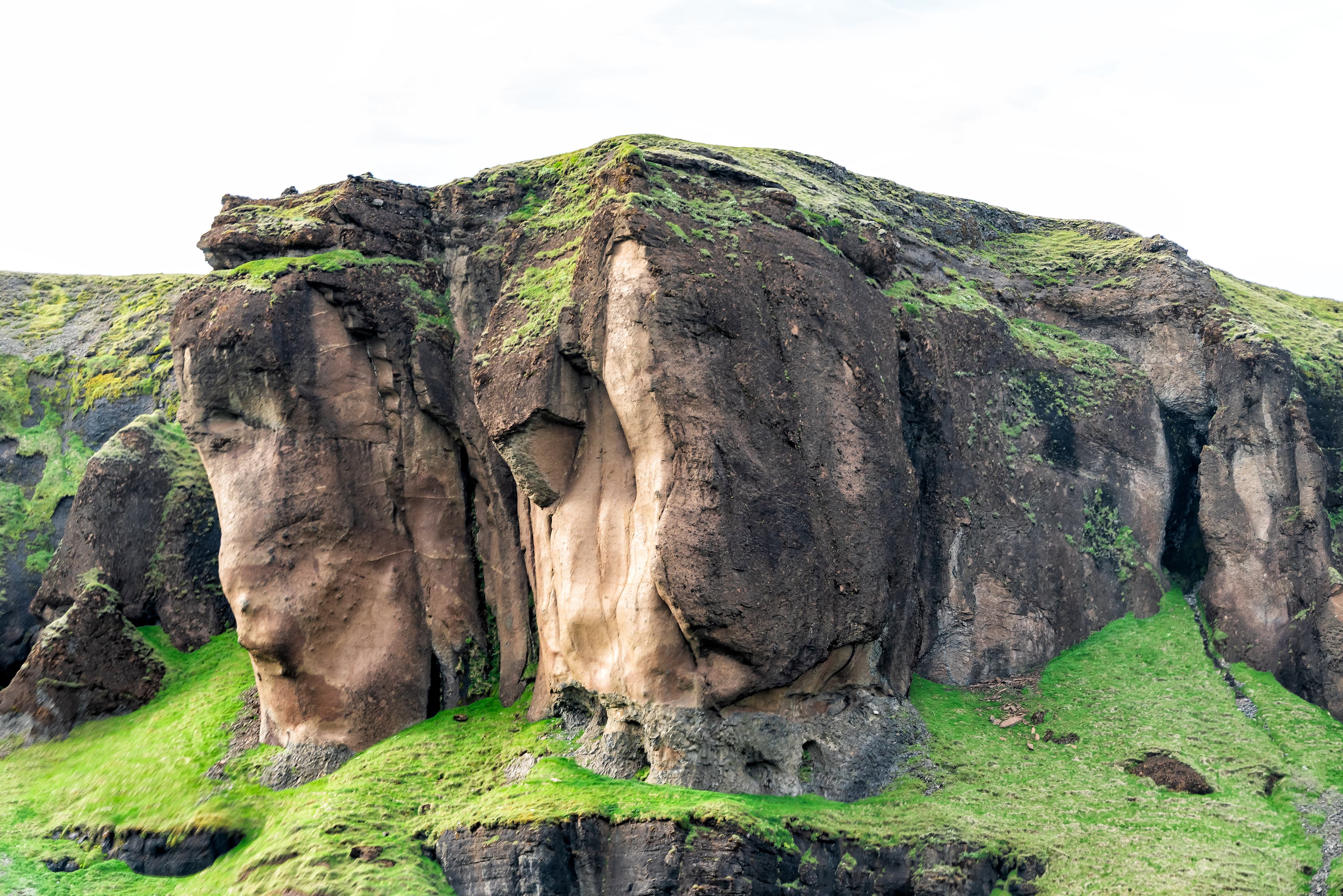 Landscape view of canyon shape in Fjadrargljufur, Iceland with large cliffs and green moss grass Landscape view of canyon shape in Fjadrargljufur, Iceland with large cliffs and green moss grass