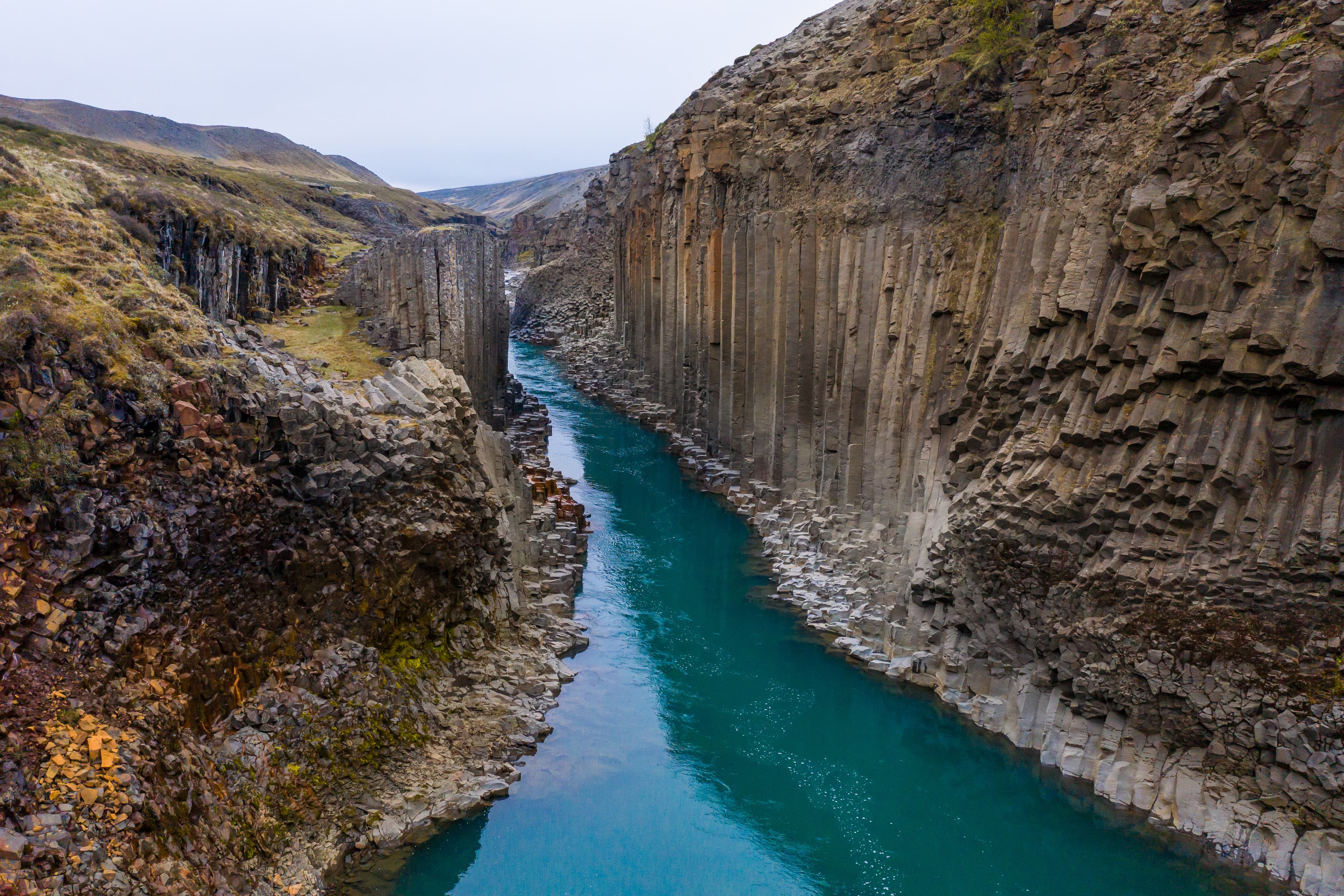 Studlagil canyon with turquoise water stream and basalt columns Studlagil canyon with turquoise water stream and basalt columns