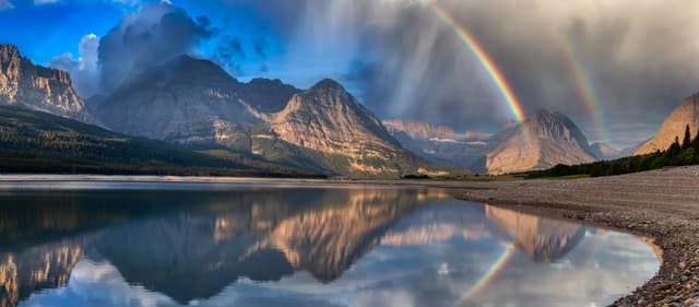 Beautiful Panoramic View of American Rocky Mountain Landscape. Dramatic Sunrise Sky with Rainbow. Art Render. Taken in Glacier National Park, Montana, United States. Beautiful Panoramic View of American Rocky Mountain Landscape
