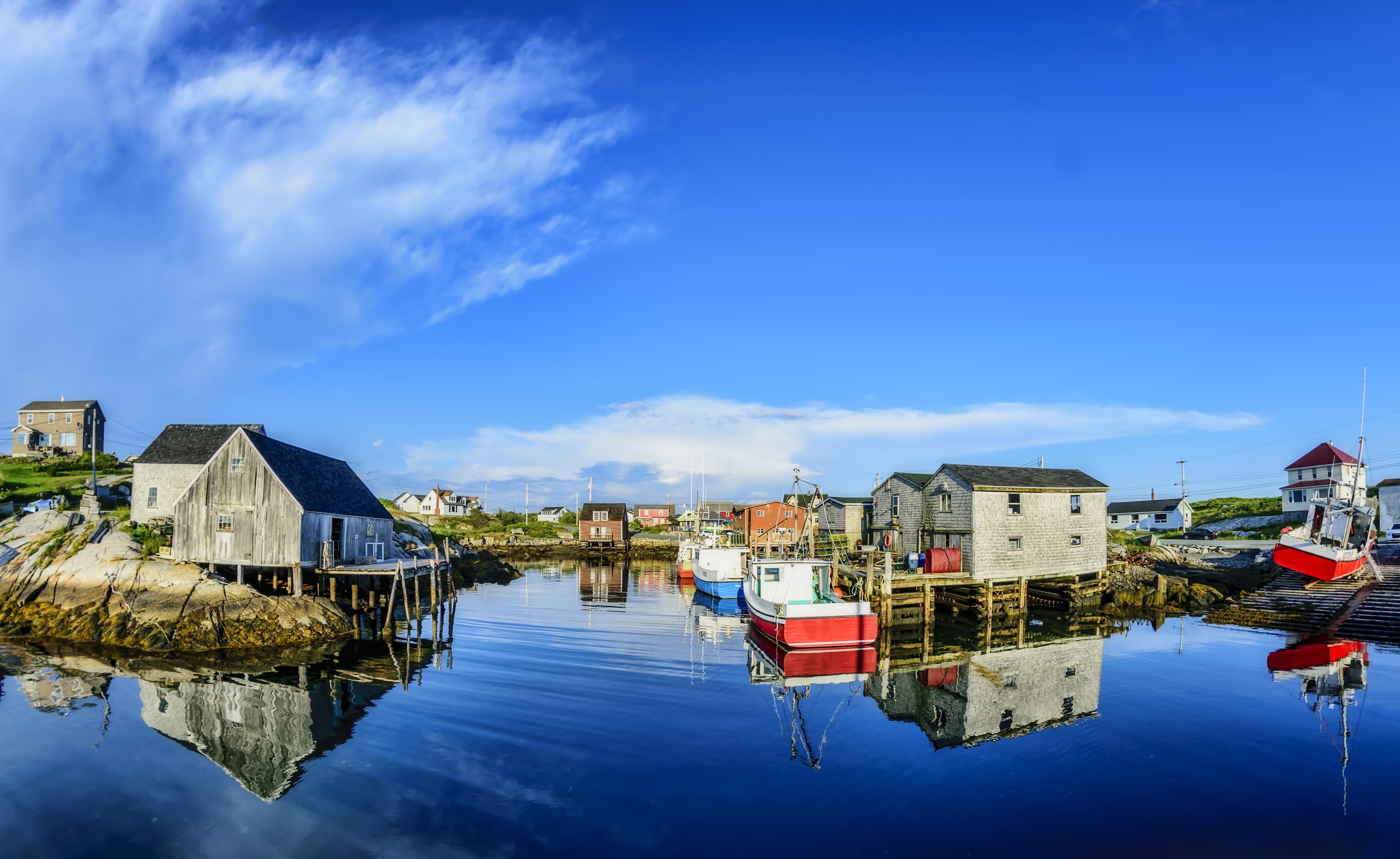 A calm summer evening in the fishing village of Peggys Cove, Nova Scotia. Local buildings and boats cast mirror like reflections in the near still Atlantic Ocean. July 24, 2016...Camera: Nikon D3300 & Bower 8mm fisheye lens..http://kenmo.fineartamerica.com/.http://kenmo.zenfolio.com/ The Best of Halifax Tour with Peggy's Cove 1