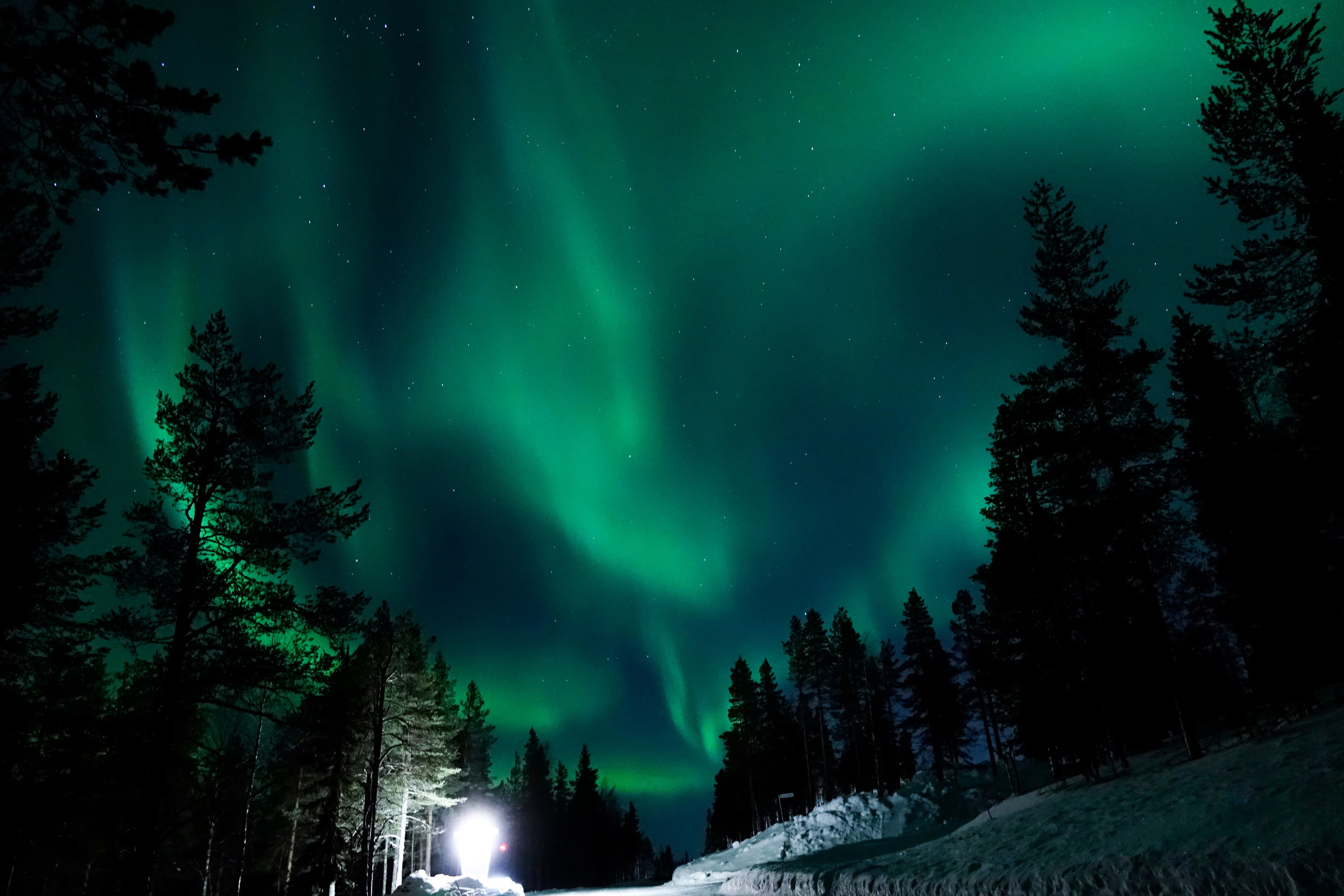 Large lamp illuminating the countryside for tourists to observe aurora borealis.