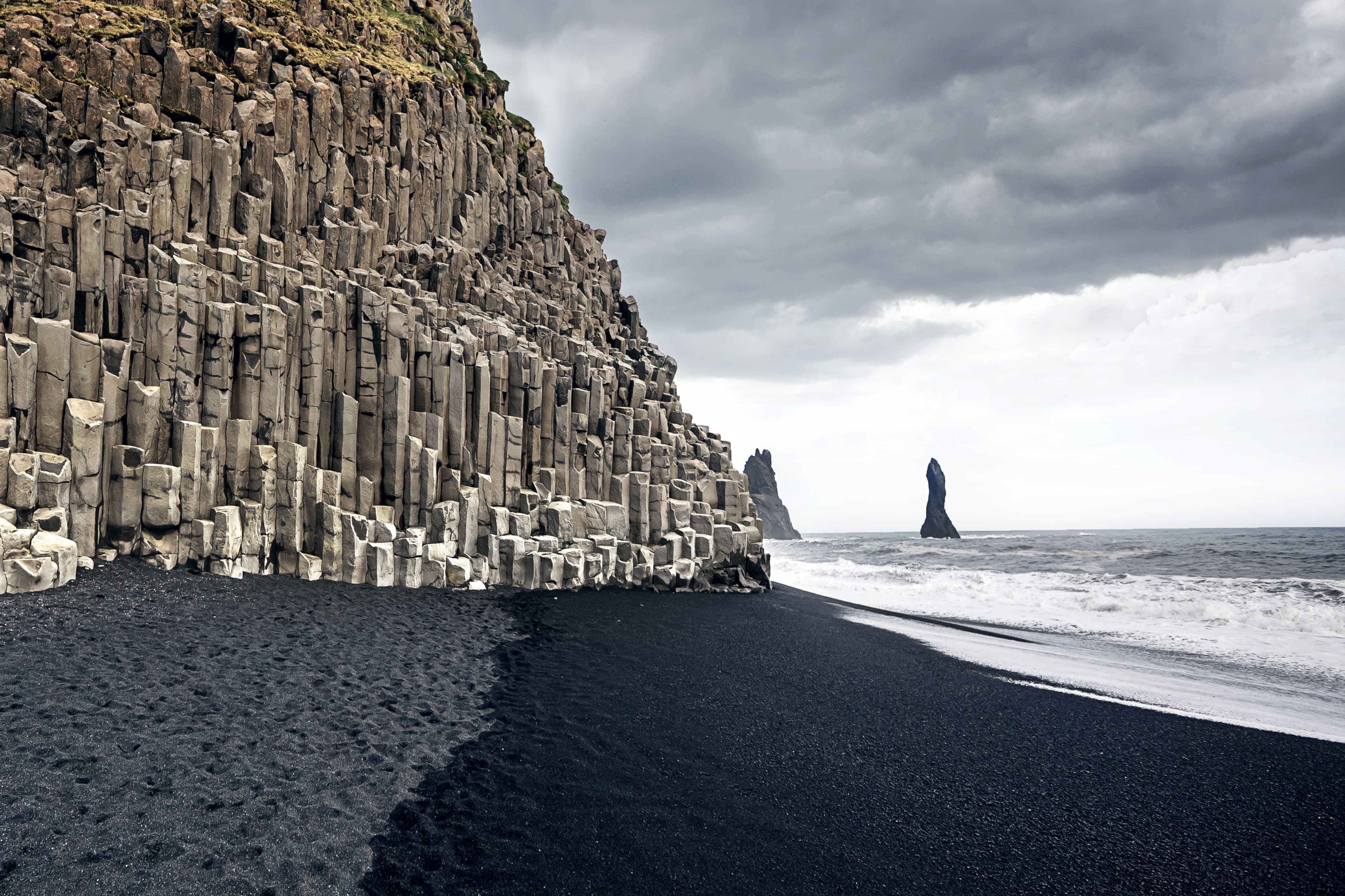 The black sand beach of Reynisfjara and the mount Reynisfjall from the Dyrholaey promontory in the southern coast of Iceland. The black sand beach of Reynisfjara in Iceland