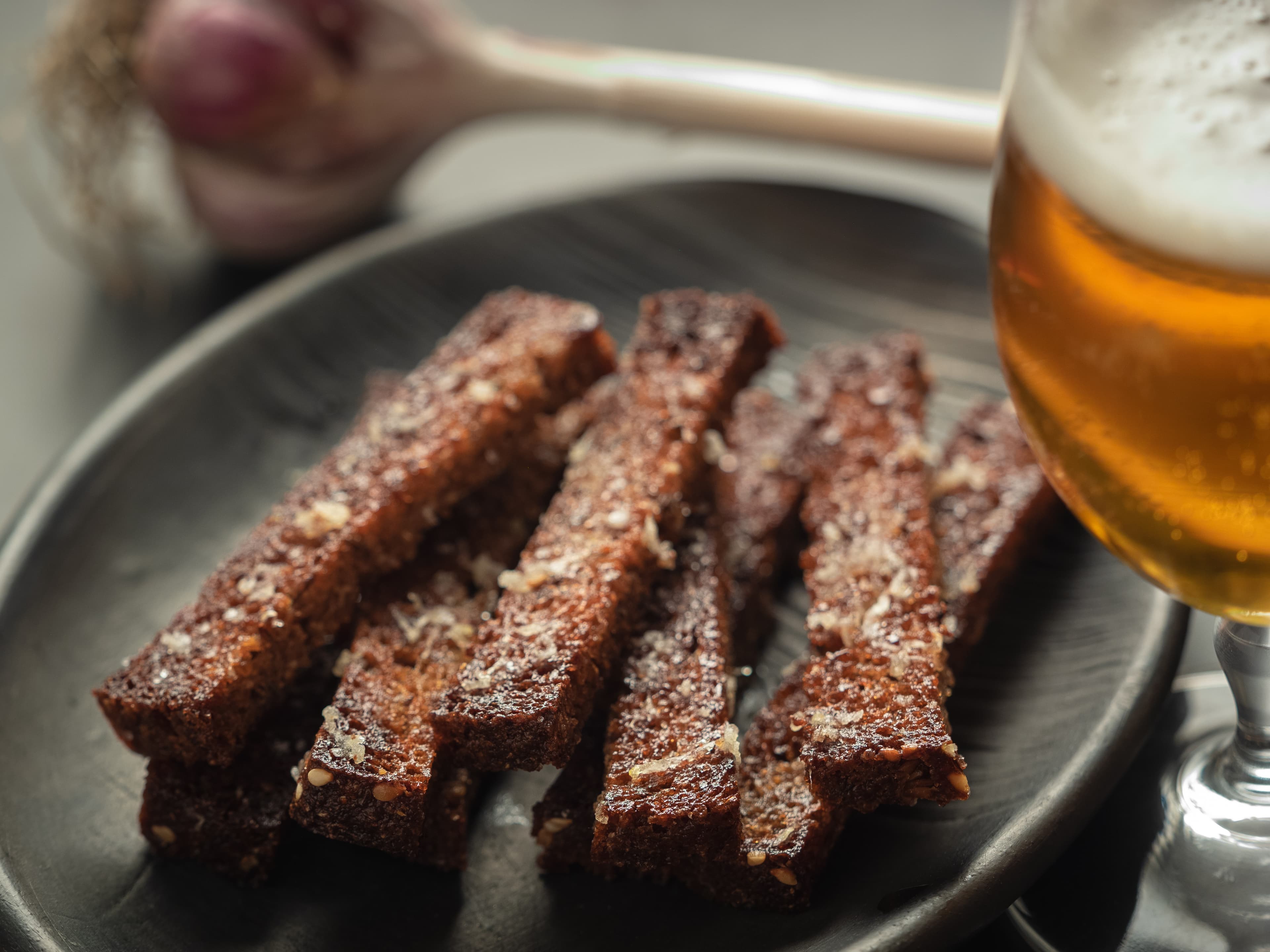 A glass of beer and rye croutons with garlic and salt