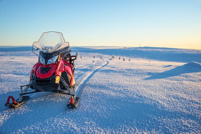 Snowmobile in a snowy landscape in Lapland, near Saariselka, Finland Snowmobile in a snowy landscape in Lapland, near Saariselka, Finland