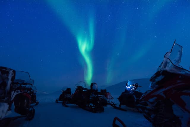The polar arctic Northern lights aurora borealis sky star in Norway Svalbard in Longyearbyen the snowmobile mountains