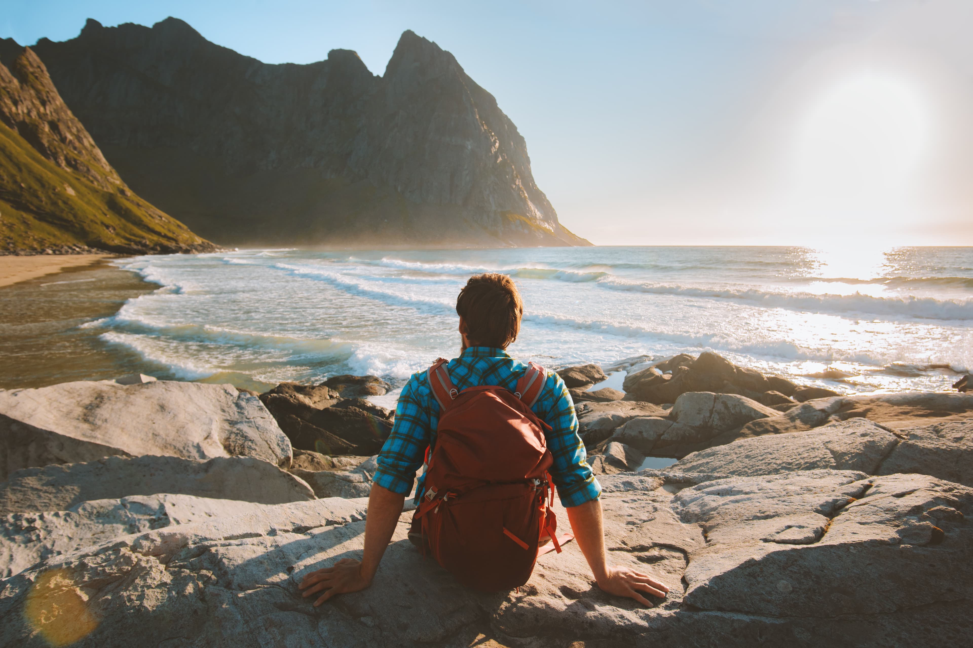 Man sitting on Kvalvika beach enjoying ocean view travel vacations eco tourism outdoor backpacking in Norway healthy lifestyle summer trip Man sitting on Kvalvika beach enjoying ocean view travel vacations eco tourism outdoor backpacking in Norway healthy lifestyle summer trip