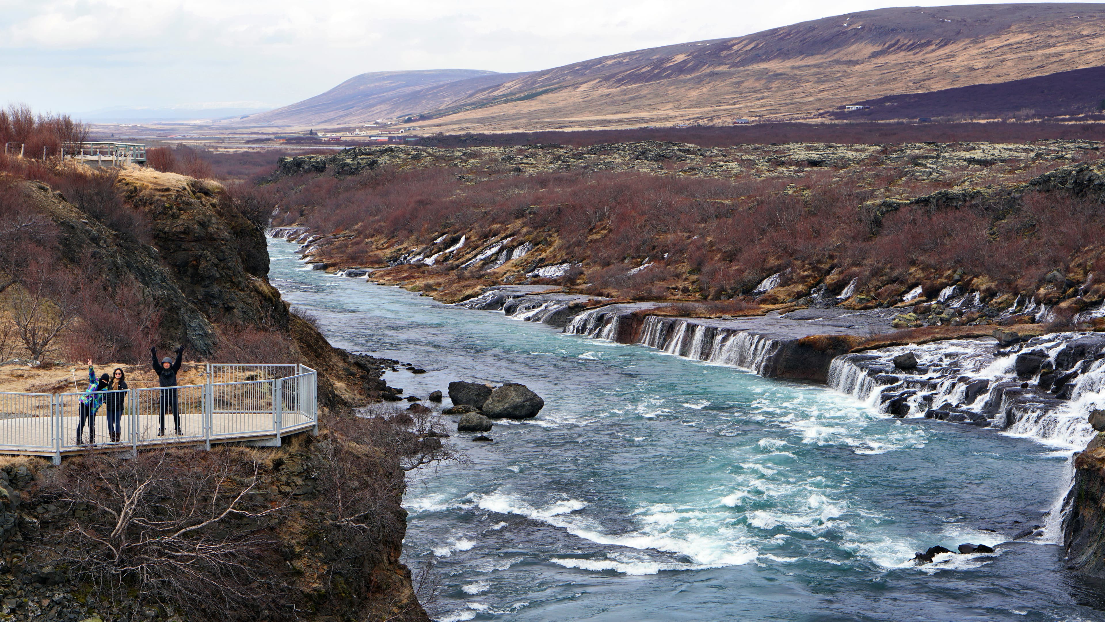 Happy Asian family travelers at hraunfossar waterfall in Iceland Happy Asian family tourists at hraunfossar waterfall in Iceland