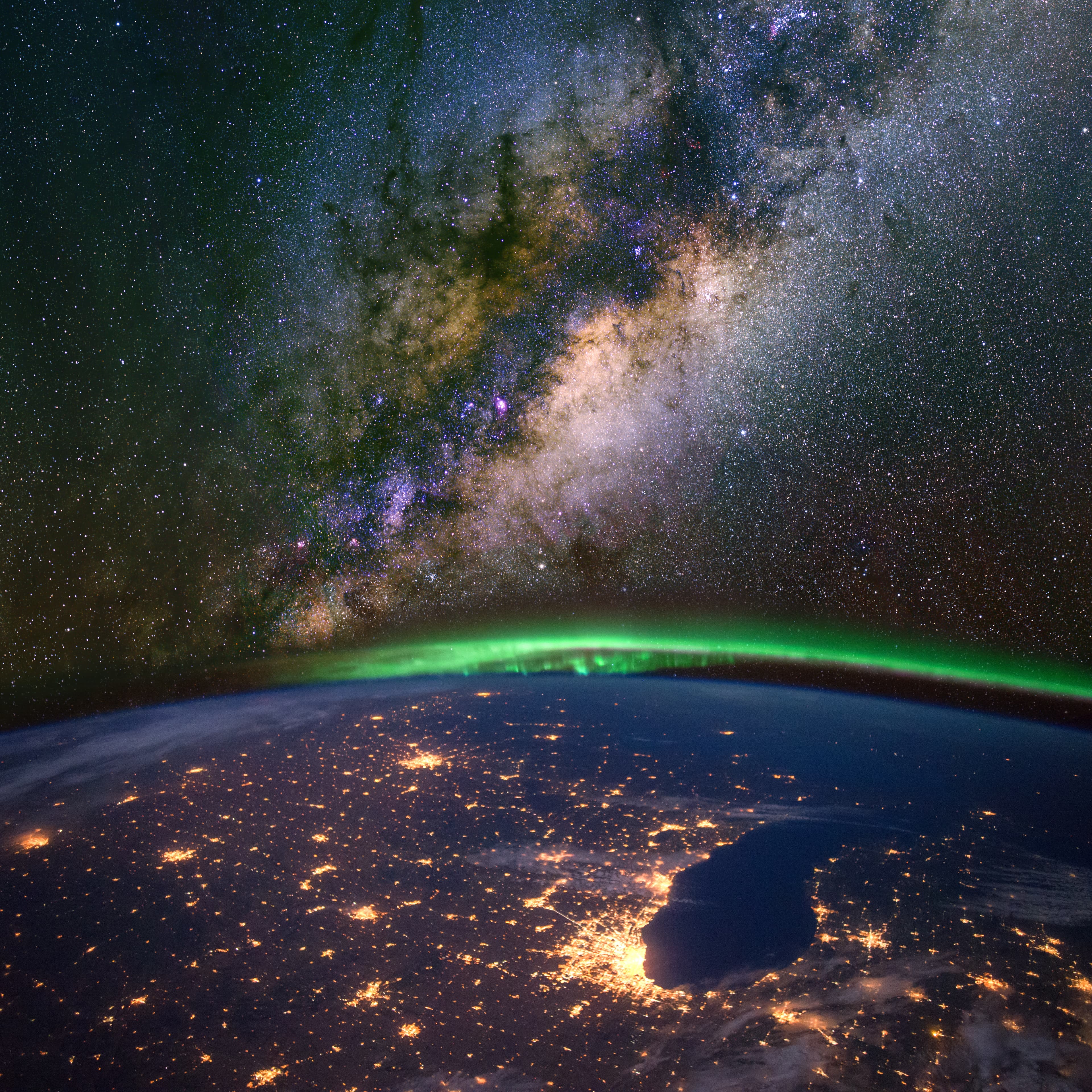 Chicago and lake Michigan from space at night, with the aurora Borealis and the Milky Way. Elements of this image furnished by NASA.
