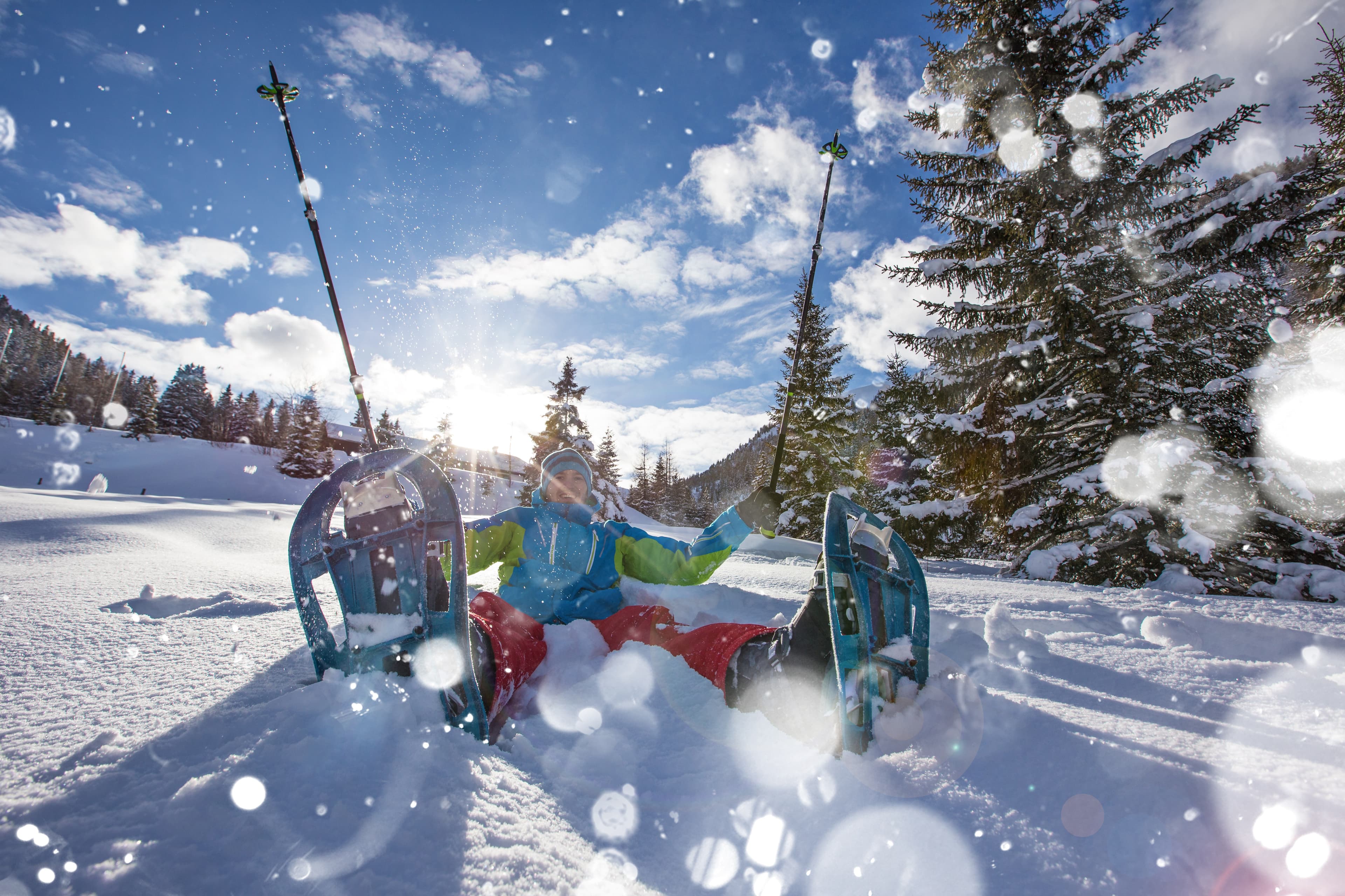 Happy snowshoe walker in powder snow with beautiful sun rays. Outdoor winter activity and healthy lifestyle Happy snowshoe walker in powder snow with beautiful sun rays.