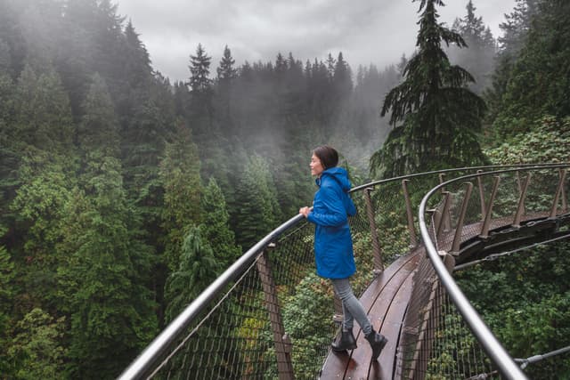 Canada Autumn travel destination in British Columbia. Asian tourist woman walking in famous attraction Capilano Suspension Bridge Park in North Vancouver, canadian vacation for tourism. Vancouver & North Vancouver Full-Day Tour 4