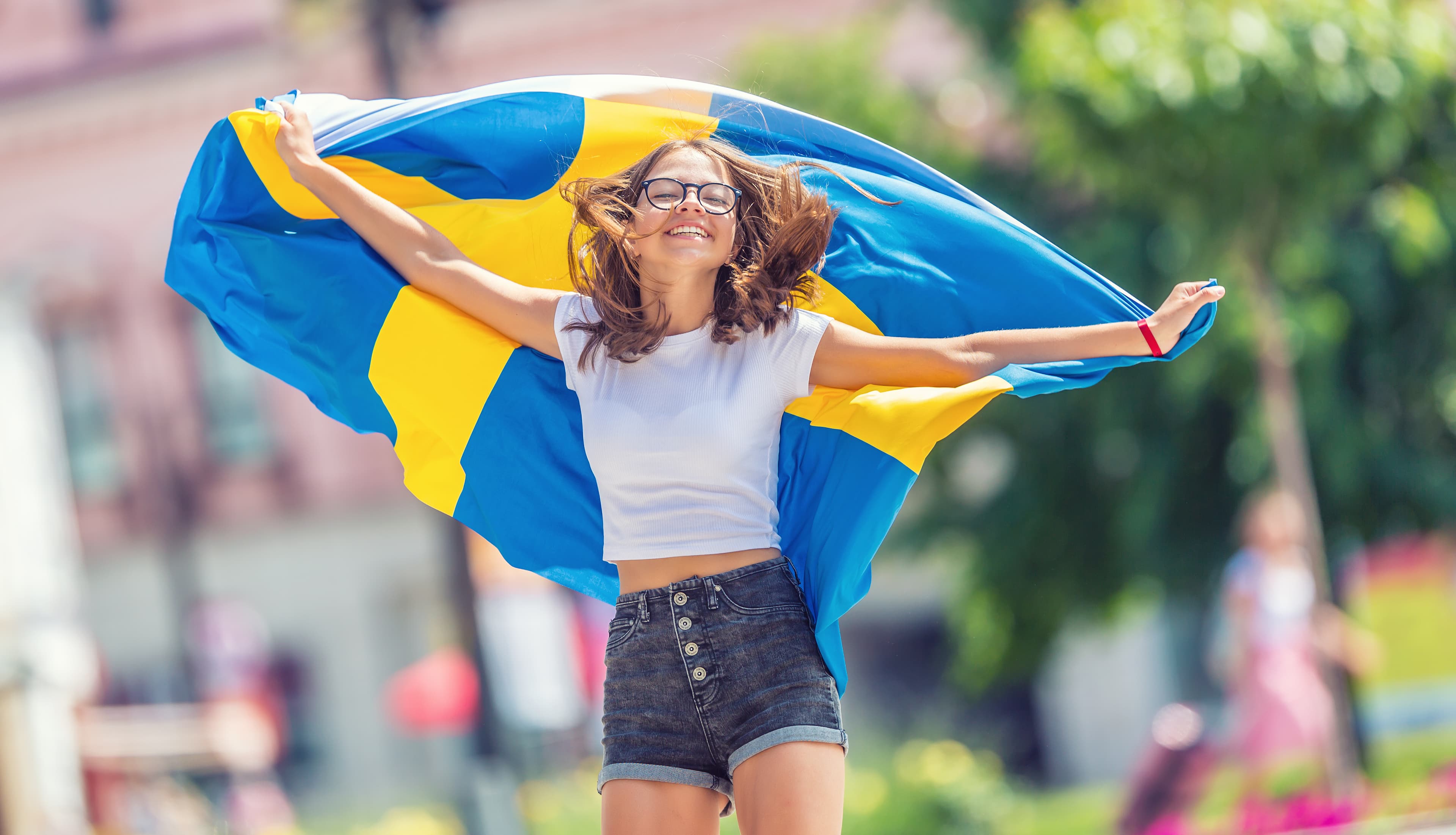 Happy girl tourist walking in the street with sweden flag. Happy girl tourist walking in the street with sweden flag
