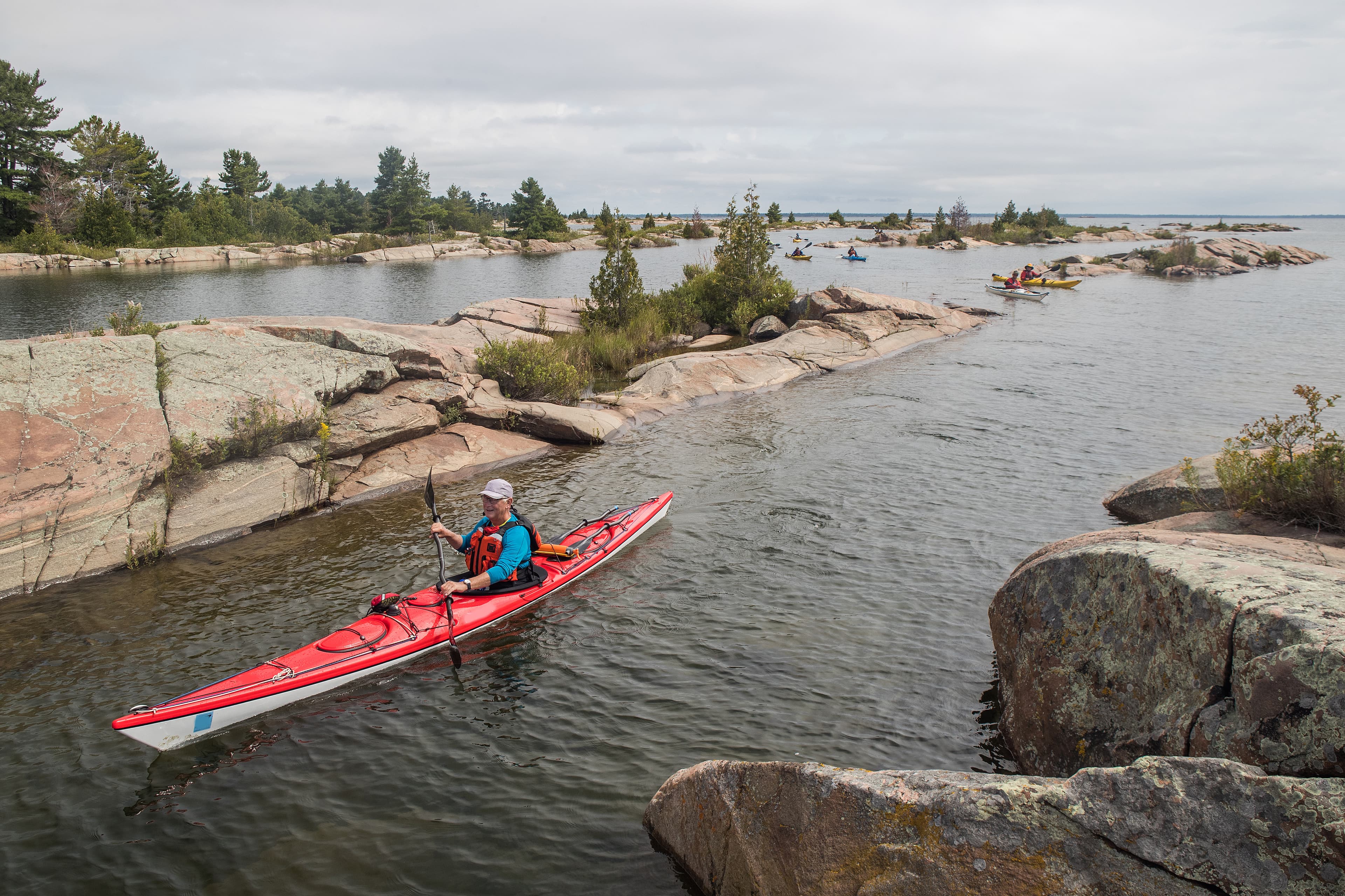 An active senior paddling a sea kayak on Georgian Bay, Ontario, Canada. Ontario Region 15
