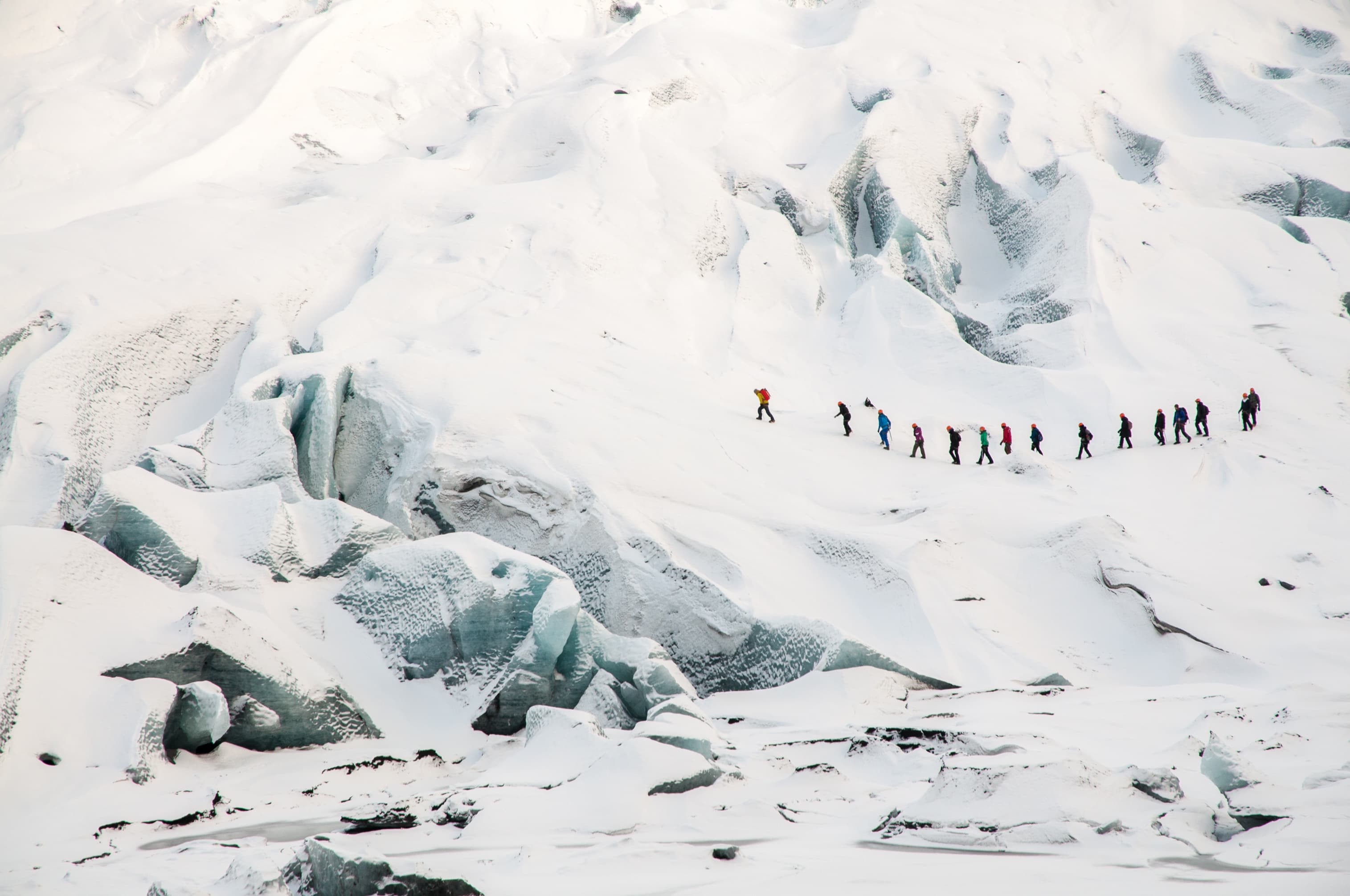Group of tourists walks on Solheimajokul Glacier in Island Group of tourists explores Solheimajokul Glacier