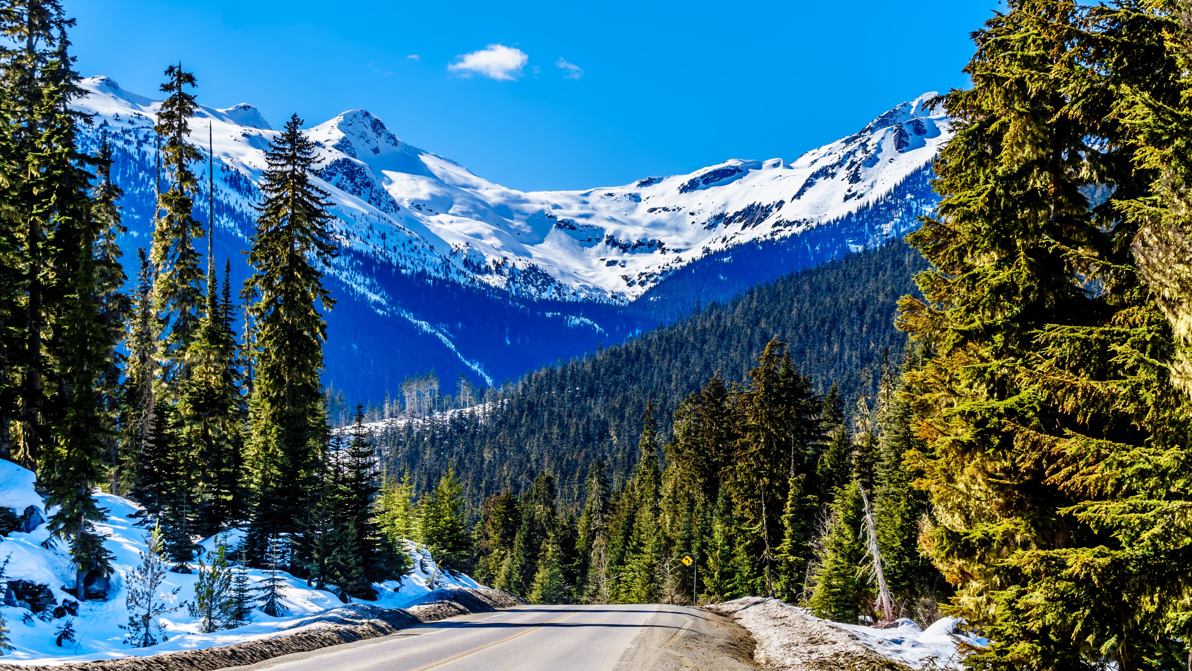 View of the snow capped Coast Mountains along Highway 99, also called The Duffey Lake Road, as it winds through the Coast Mountain Range between Pemberton and Lillooet in southern British Columbia