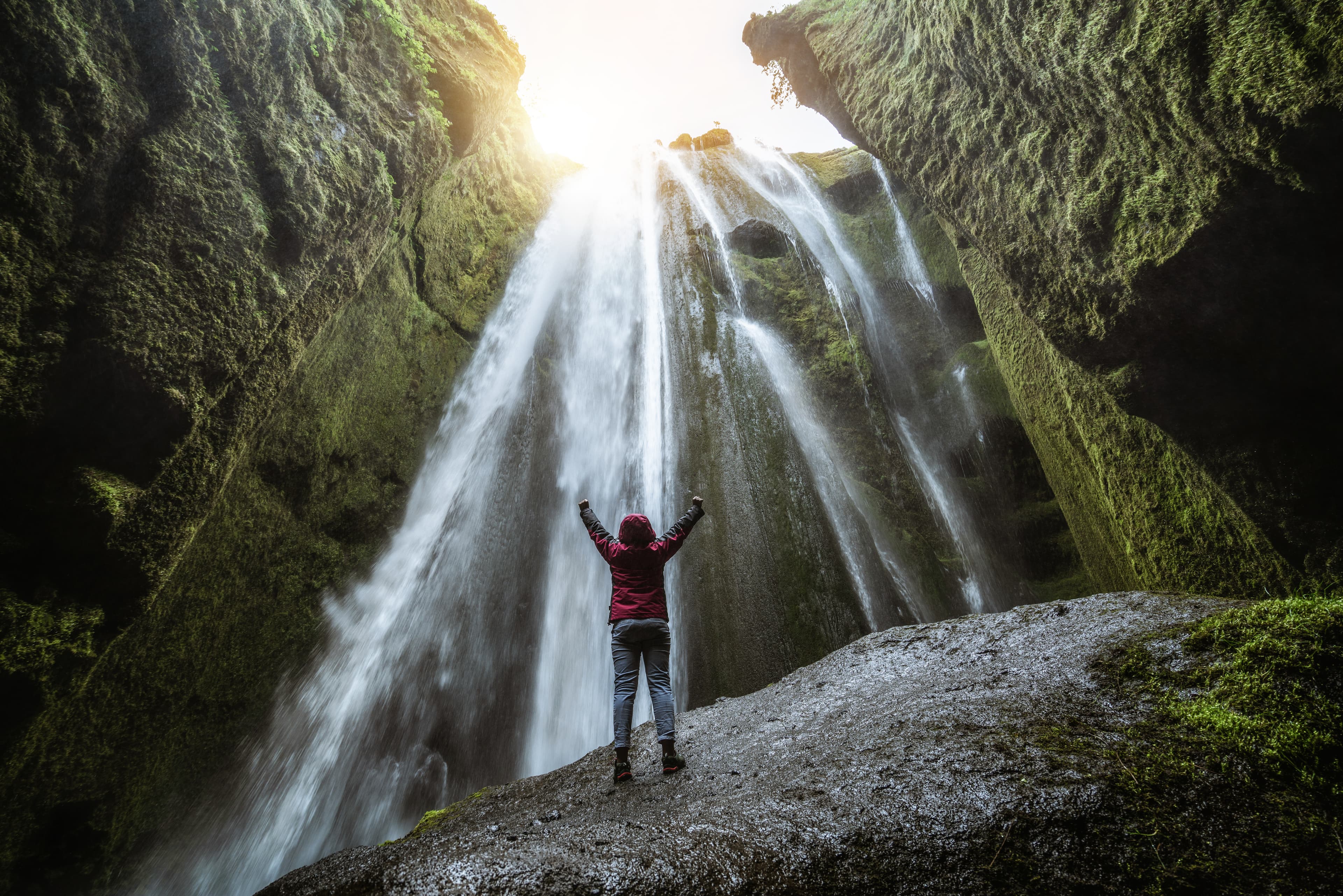 Traveler stunned by Gljufrabui waterfall cascade in Iceland. Located at scenic Seljalandsfoss waterfall South of Iceland, Europe. It is top beautiful destination of popular tourist travel attraction. Traveler stunned by Gljufrabui waterfall cascade in Iceland