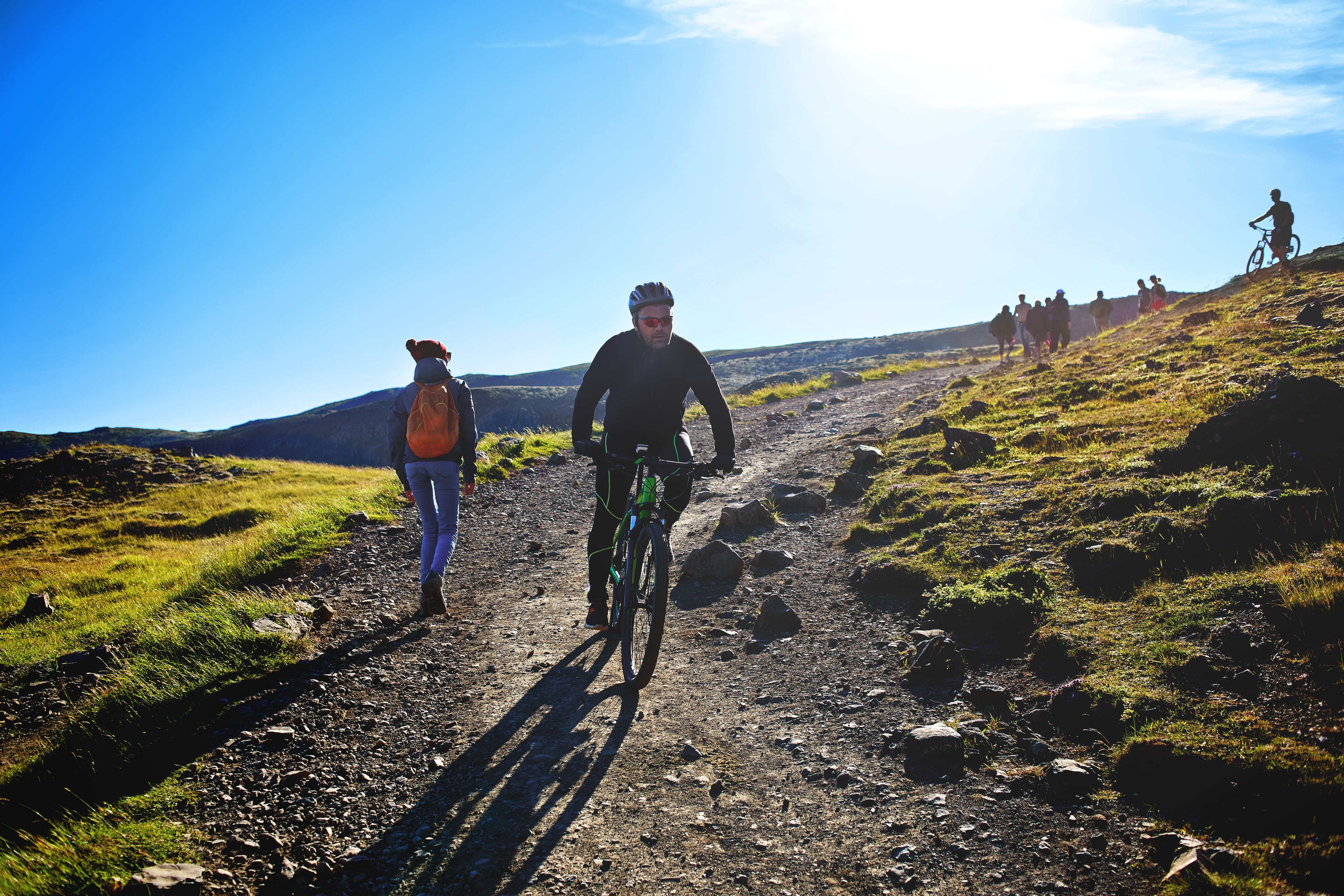 back view of woman traveler on a walk in the Valley of the river of Hveragerdi Iceland, the cyclist bikes down the slope. Hiking Tour of Reykjadalur Hot Springs woman traveler on a walk in the Valley of the river of Hveragerdi Iceland, the cyclist bikes down the slope