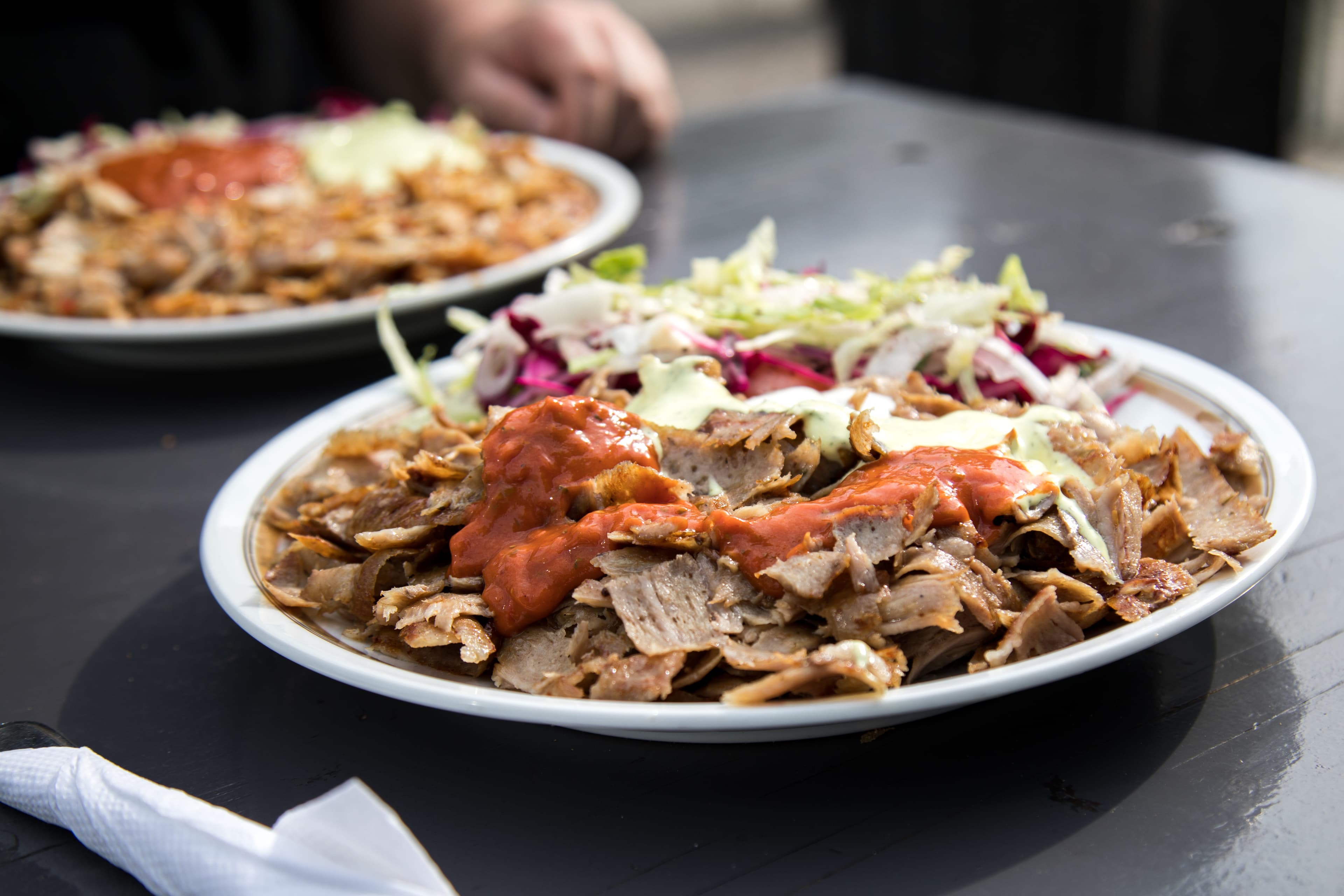 Mann isst Kalbfleisch Dönerteller mit Salat und Sauce