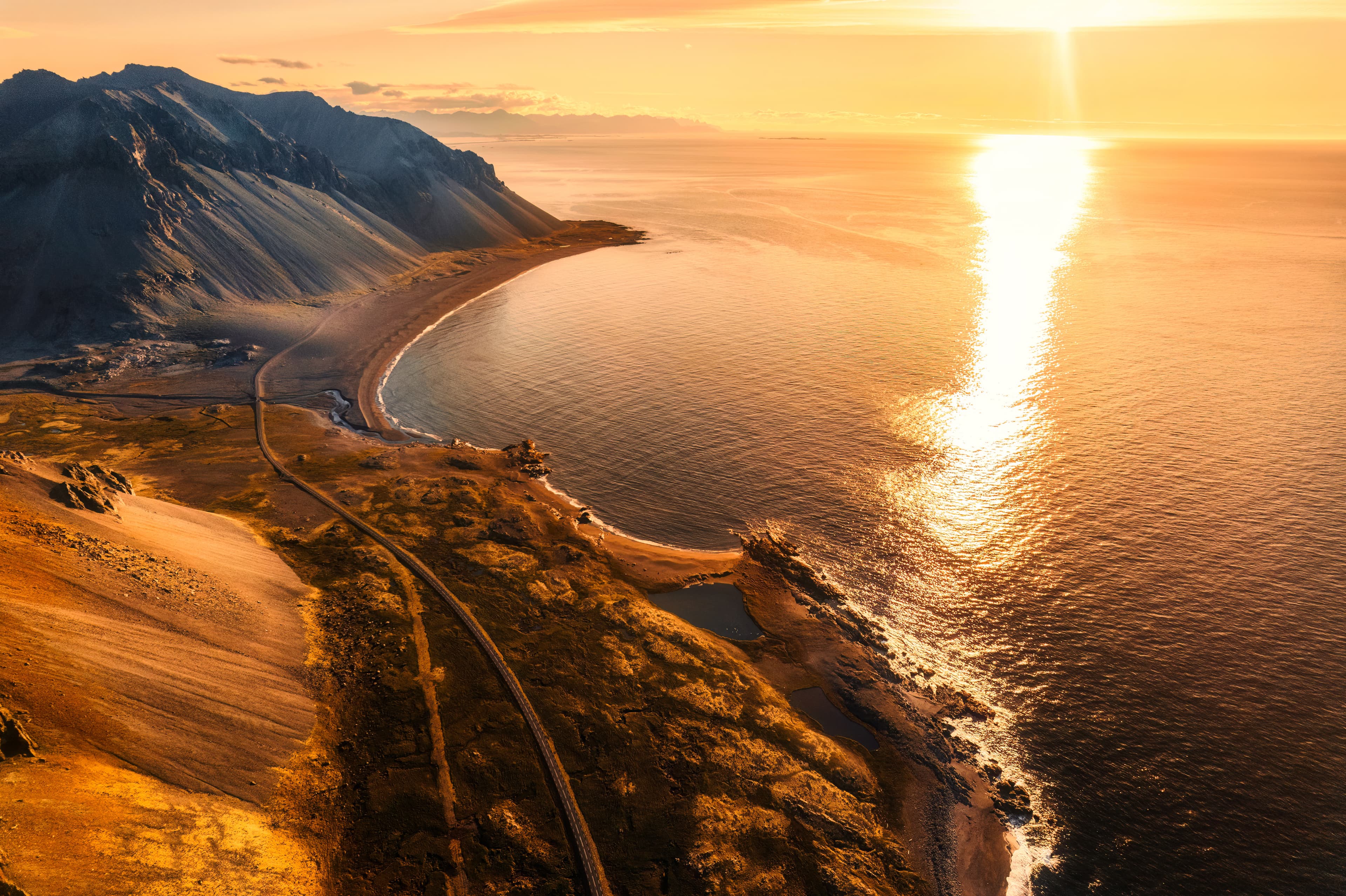 Aerial view of beautiful sunrise over volcanic mountain range in rural scene by the ocean of peninsula at summer in Iceland. Beautiful sunrise over volcanic mountain range in rural scene by the ocean of peninsula at summer in Iceland